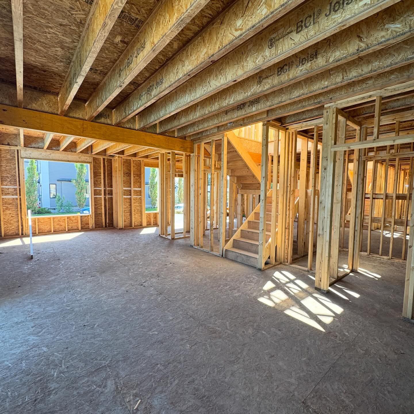 Interior of a house under construction with engineered floor joists and stud walls