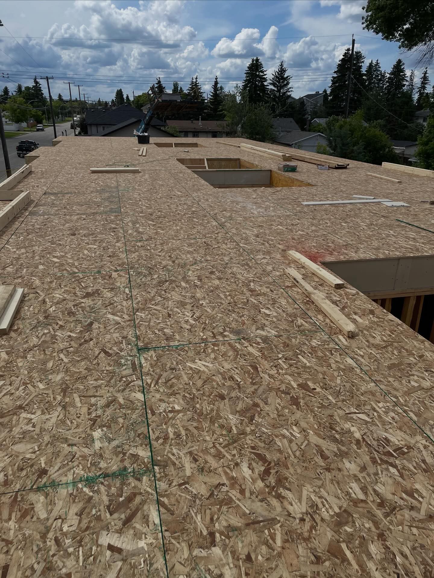 OSB subfloor deck with chalk lines and cut openings during framing