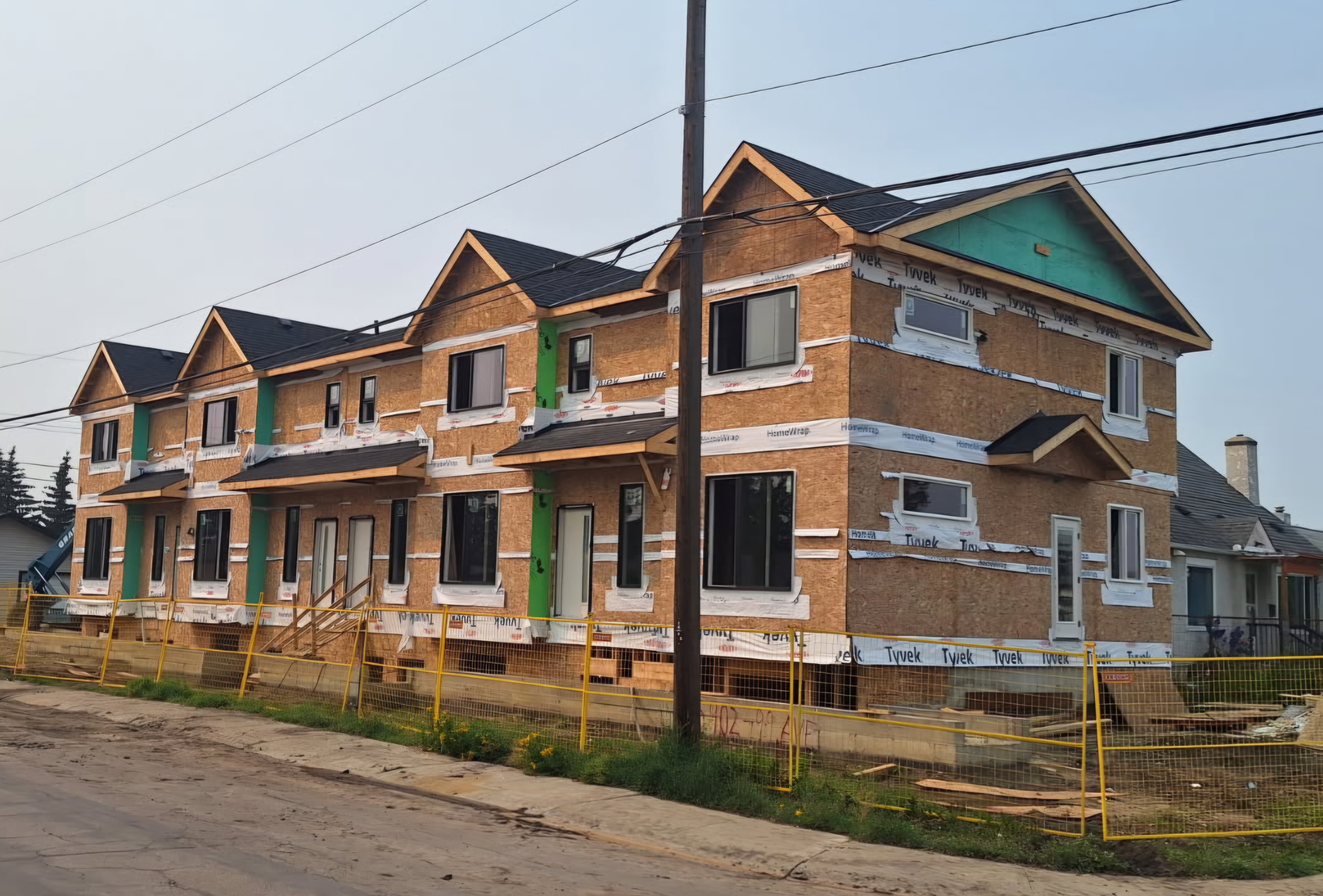 Row of townhouses under construction with shingled gables