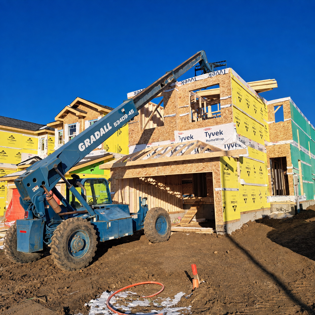 Telehandler moving framing material on a Miles Of Construction jobsite